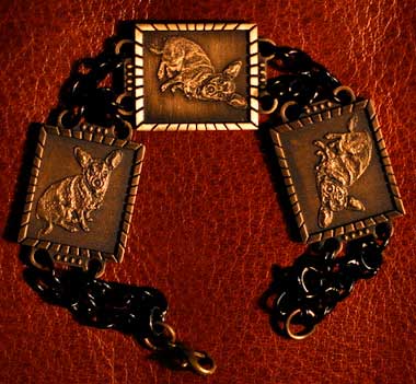 3 Bronze Jewelry Pendants connected to a black chain as a bracelet